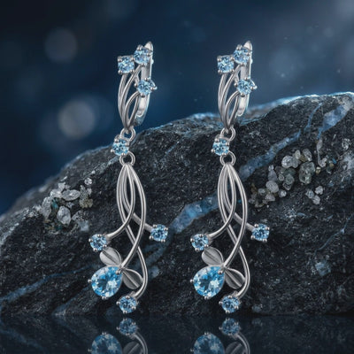 A pair of solid gold earrings with natural blue topaz gemstones.