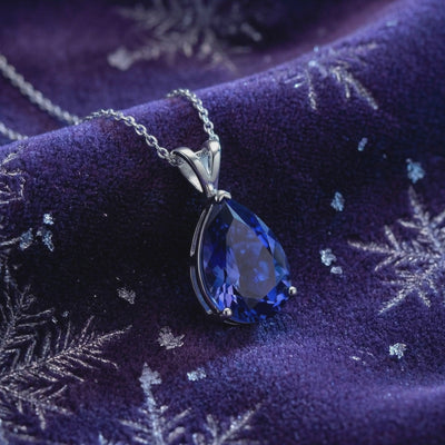 The Calystine Pear solid gold necklace with a pear-cut blue moissanite pendant.