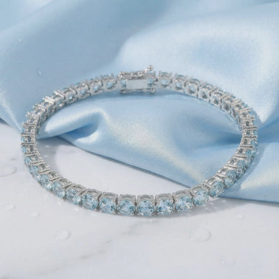 Simulated aquamarine tennis bracelet in solid gold.