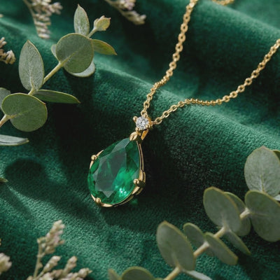 Solid gold necklace with pear-cut simulated emerald.