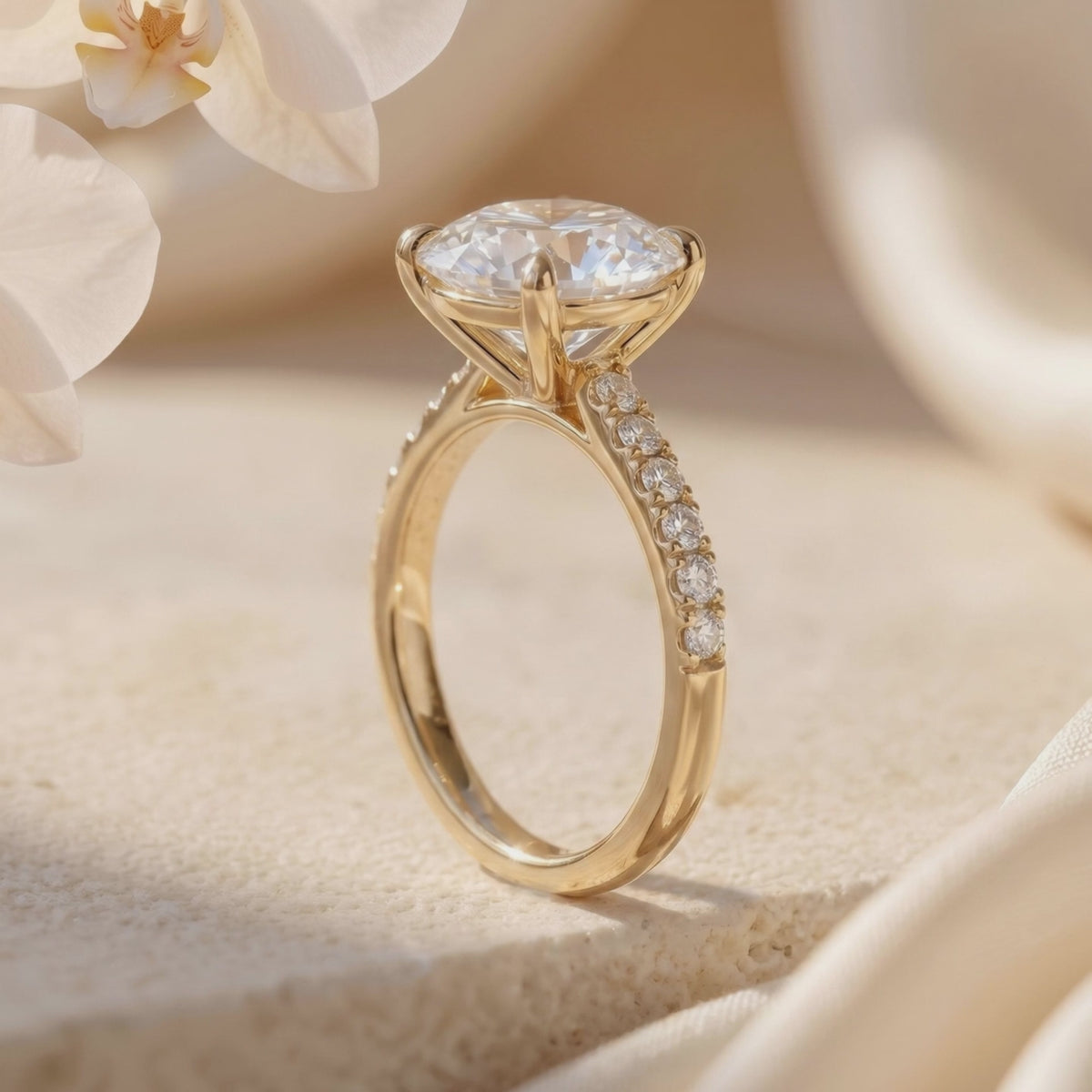 Side profile of a yellow-gold-tone solitaire ring showing the round center stone and pavé stones along the band.