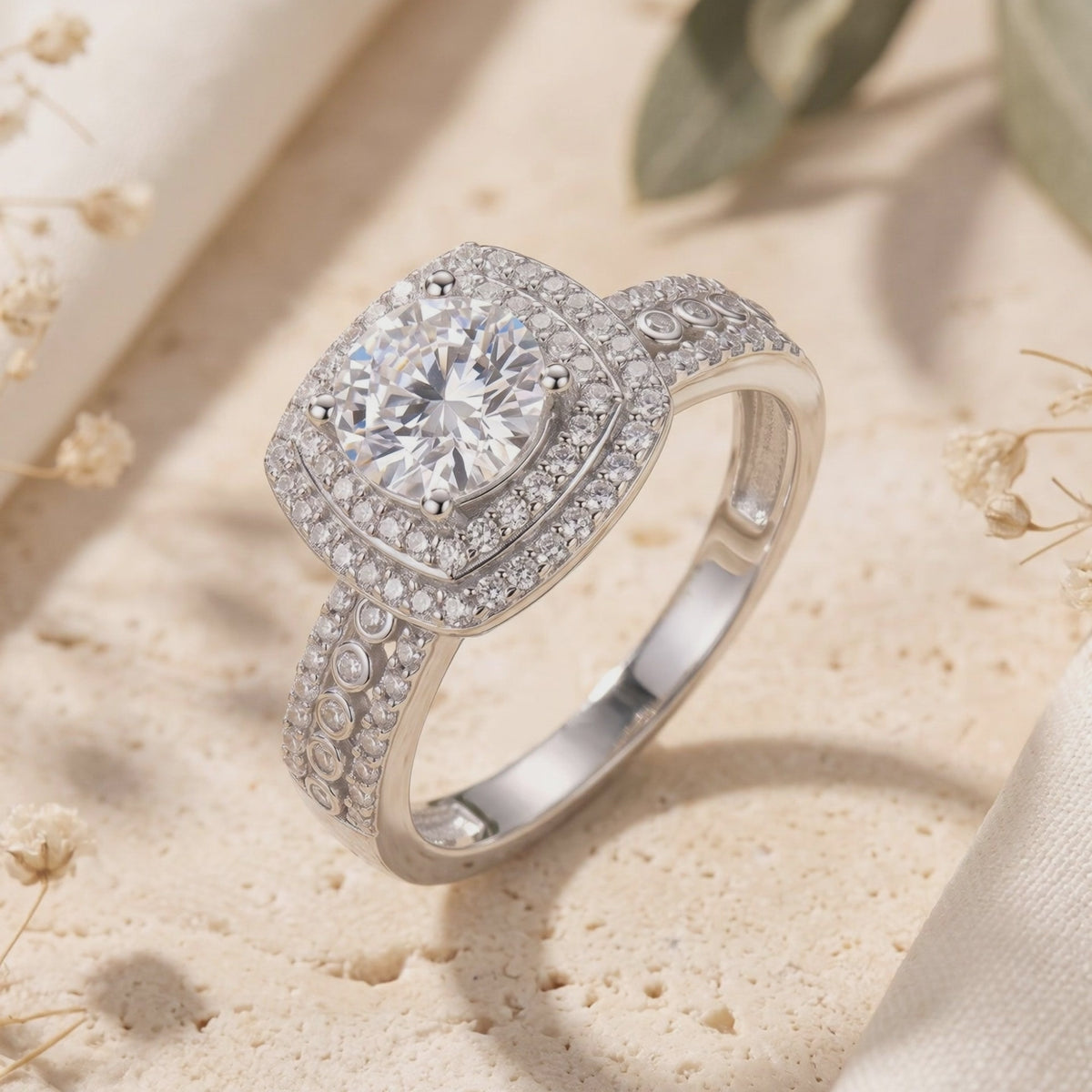 Macro view of the silver cushion double halo ring showing the round center stone and patterned band.