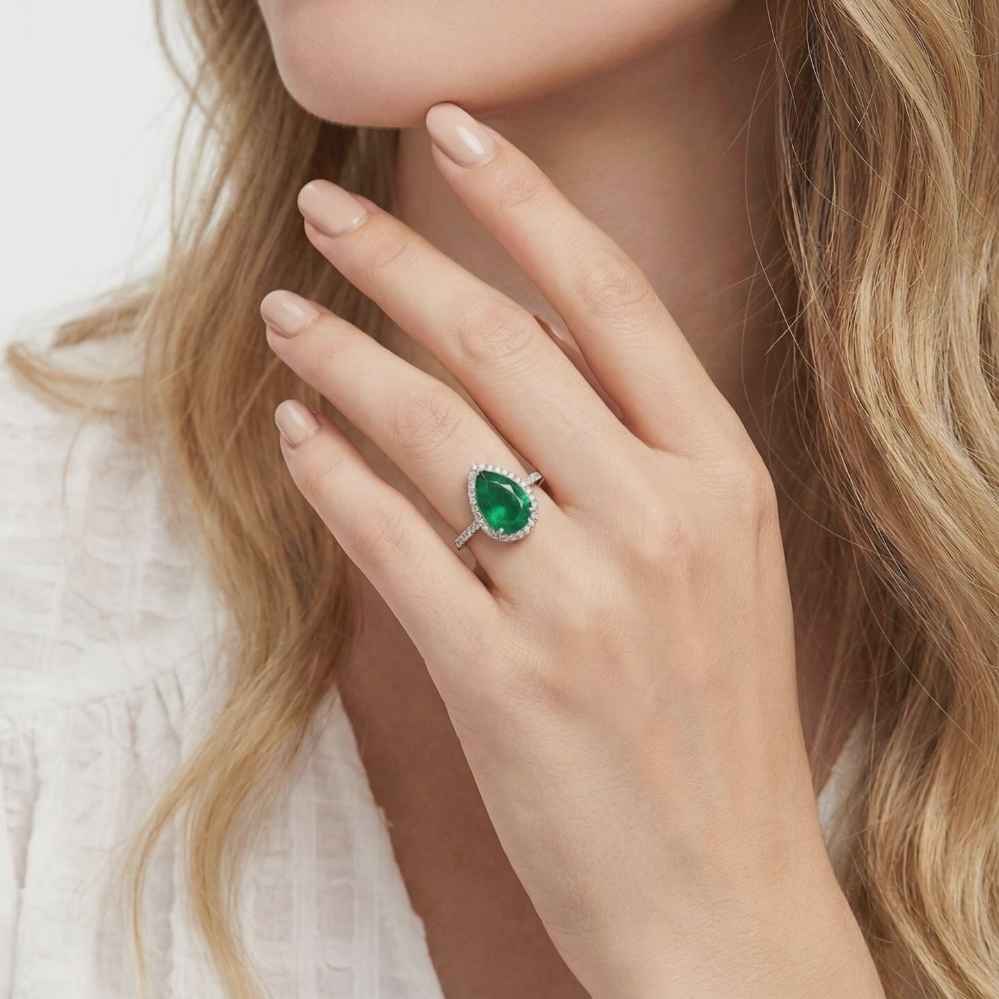 A solid gold ring with a pear-cut simulated emerald.