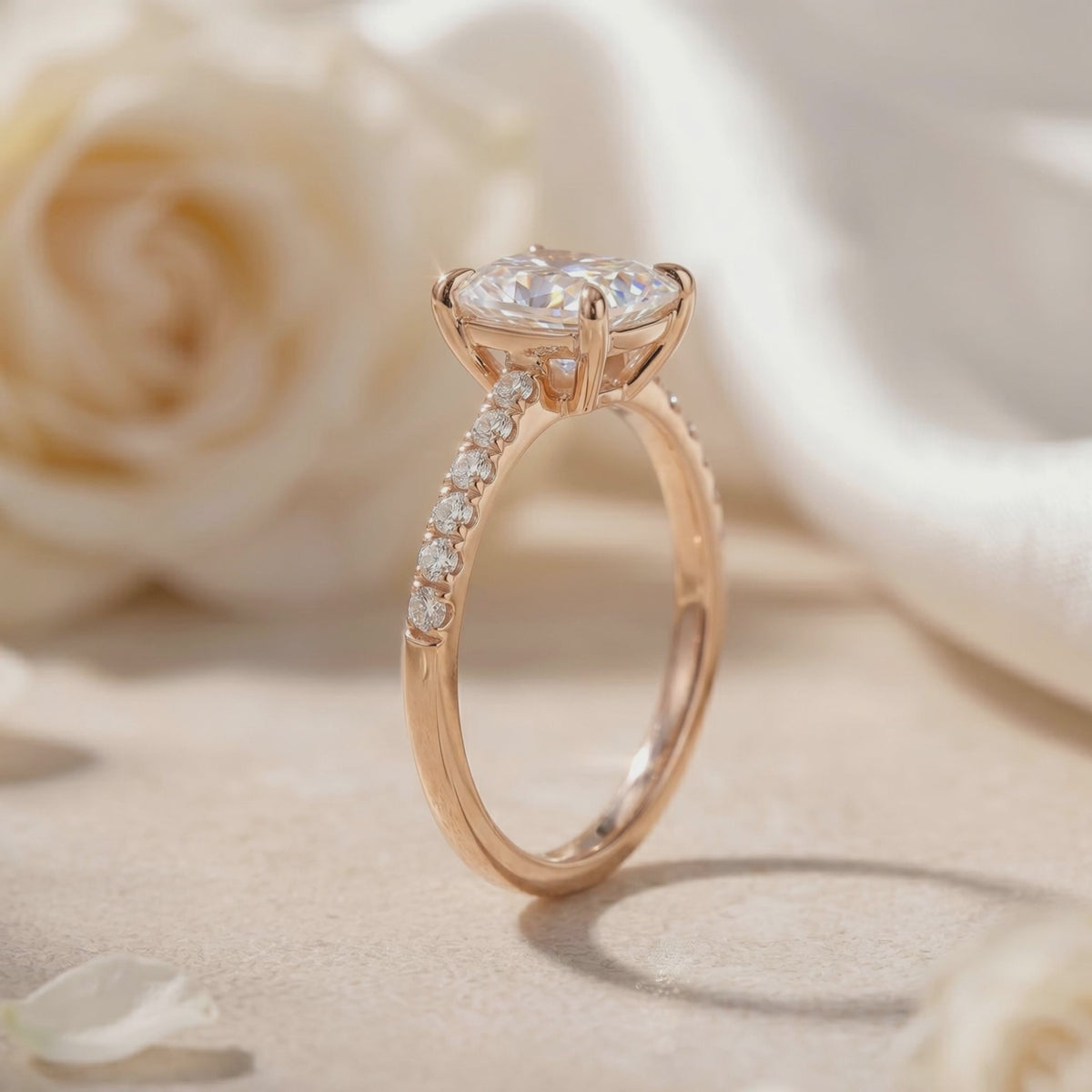 Side profile of the cushion rectangular pavé solitaire ring on a neutral backdrop with white roses.