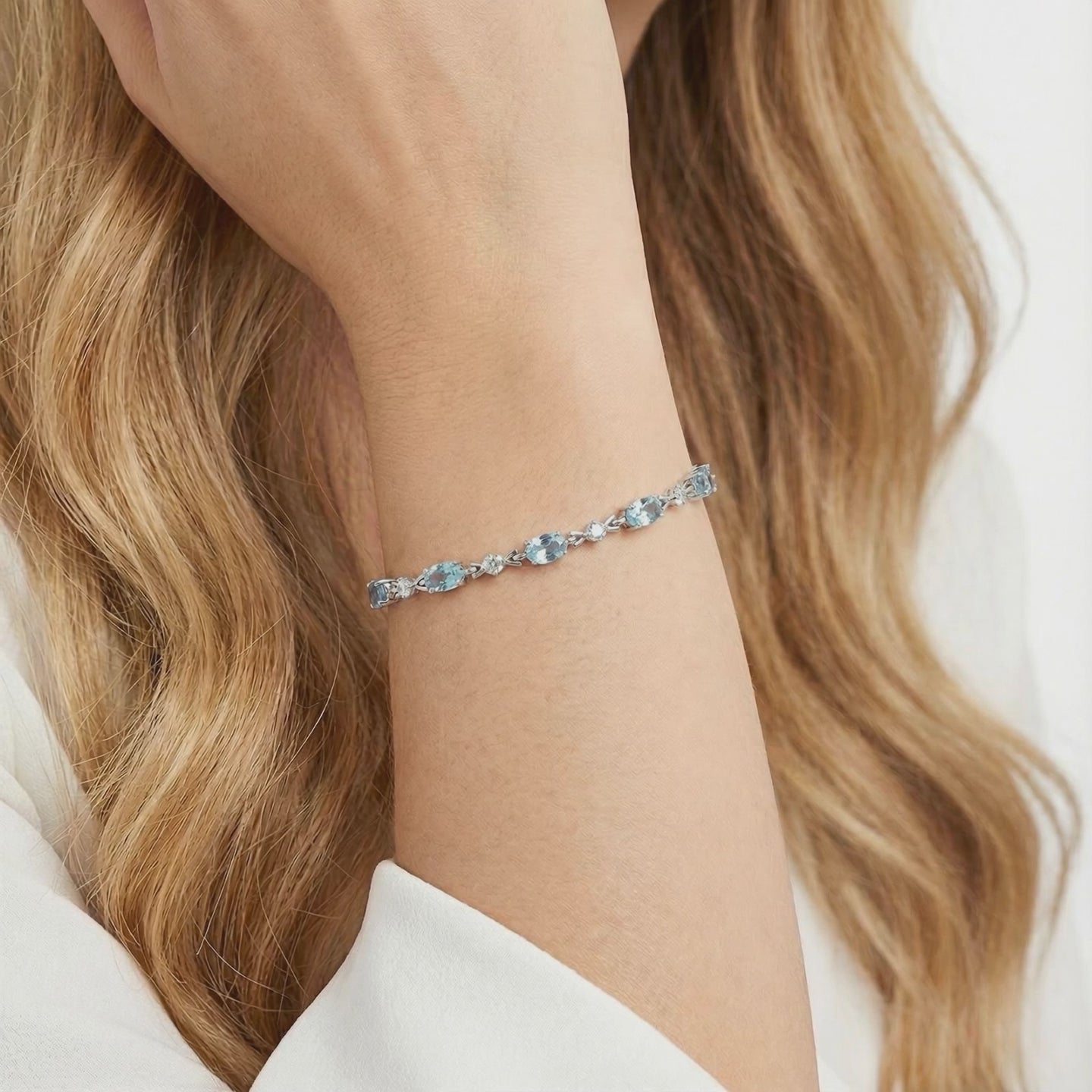 Melodia station bracelet with simulated aquamarine stones in solid gold.