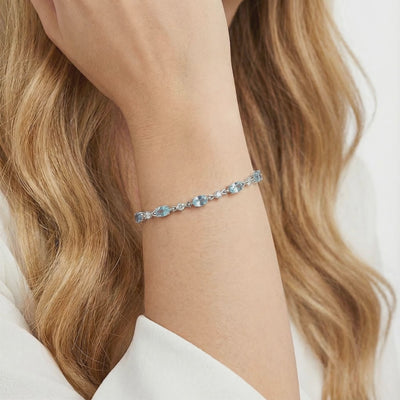 Melodia station bracelet with simulated aquamarine stones in solid gold.