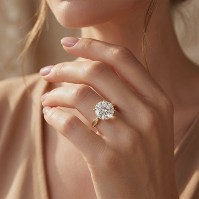 Model wearing a yellow gold-toned twisted pavé ring with a large round-cut center stone.