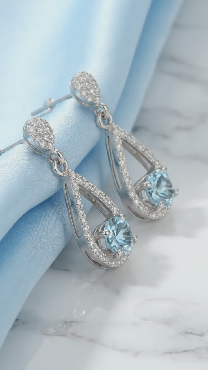 Video of solid gold teardrop drop earrings with simulated aquamarine.