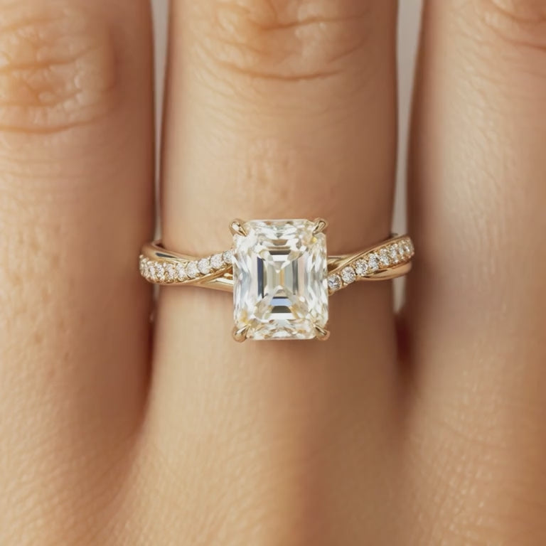 Emerald cut moissanite twisting eternity ring in solid gold
