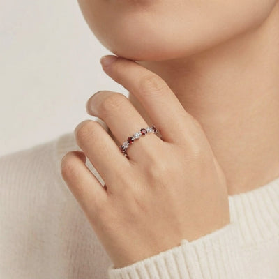 A solid gold eternity ring with simulated garnets.