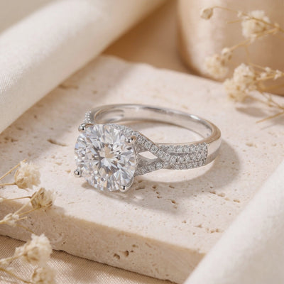 Video preview of the silver twisted solitaire ring with a pavé split shank resting on a beige stone surface.