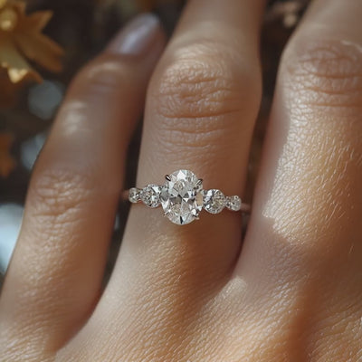 A solid gold ring with an oval moissanite center stone and round side stones.
