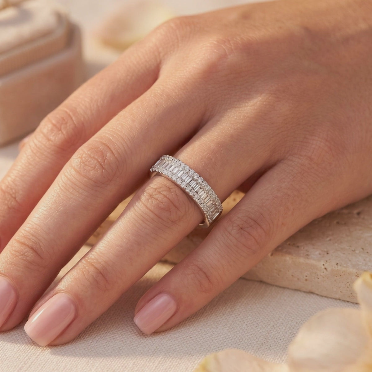 Silver channel-set band with baguette and micro-pavé cubic zirconia, worn on a ring finger.