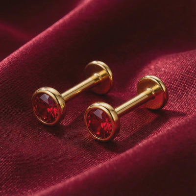 Solid gold stud earrings with simulated rubies.