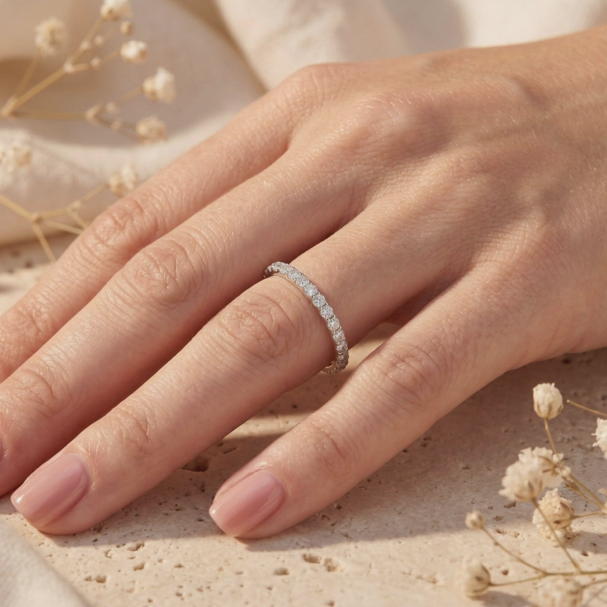 Video preview of a slim silver pave ring with round moissanite stones worn on a hand.