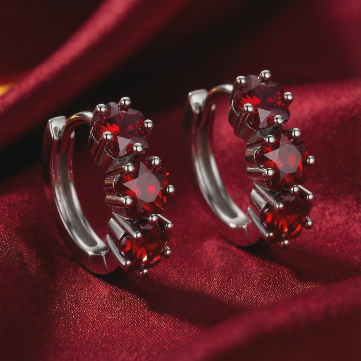 Star-cut simulated ruby huggie hoop earrings in solid gold.