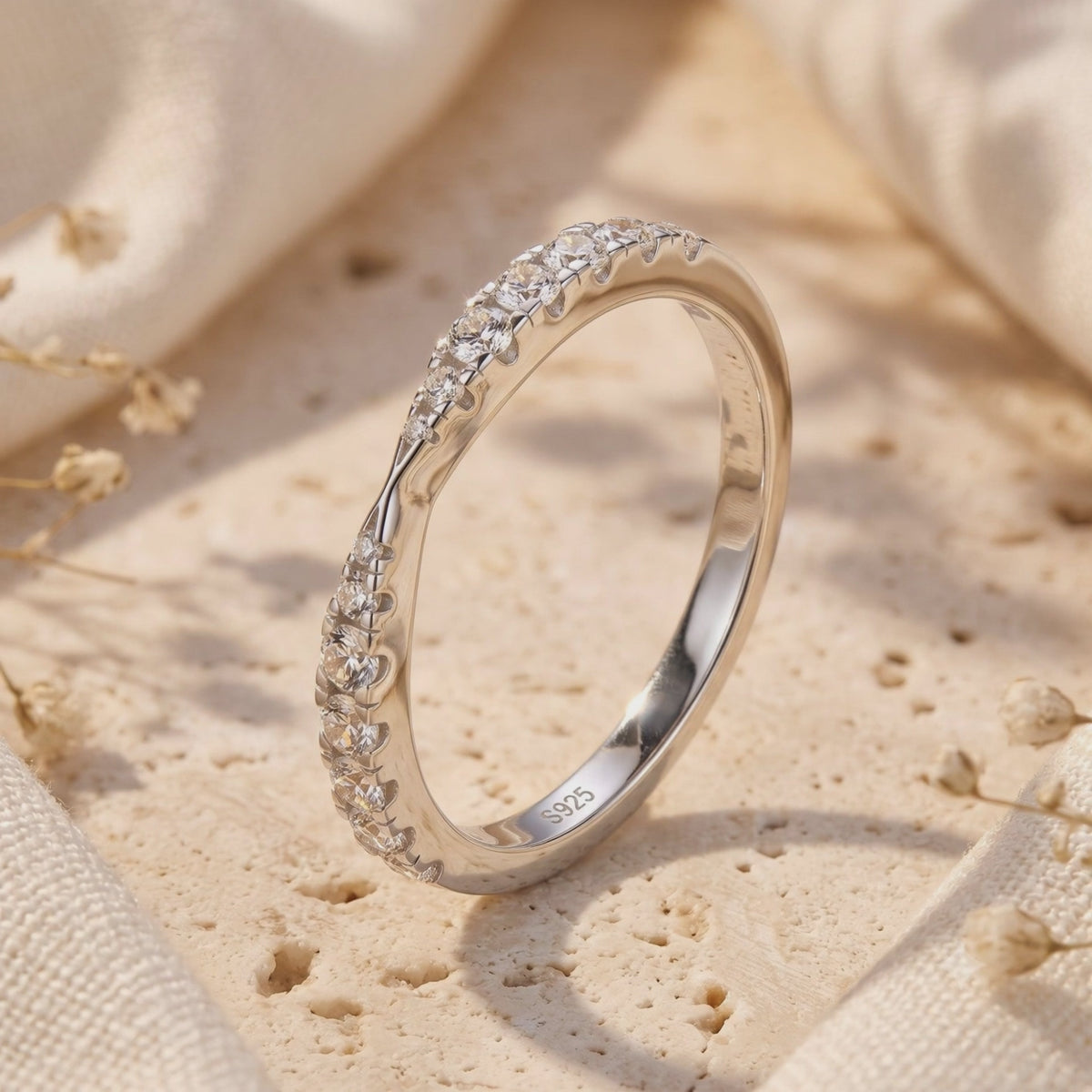 Close-up of the silver contoured wave ring showing pavé-set stones and an S925 inner-band stamp.