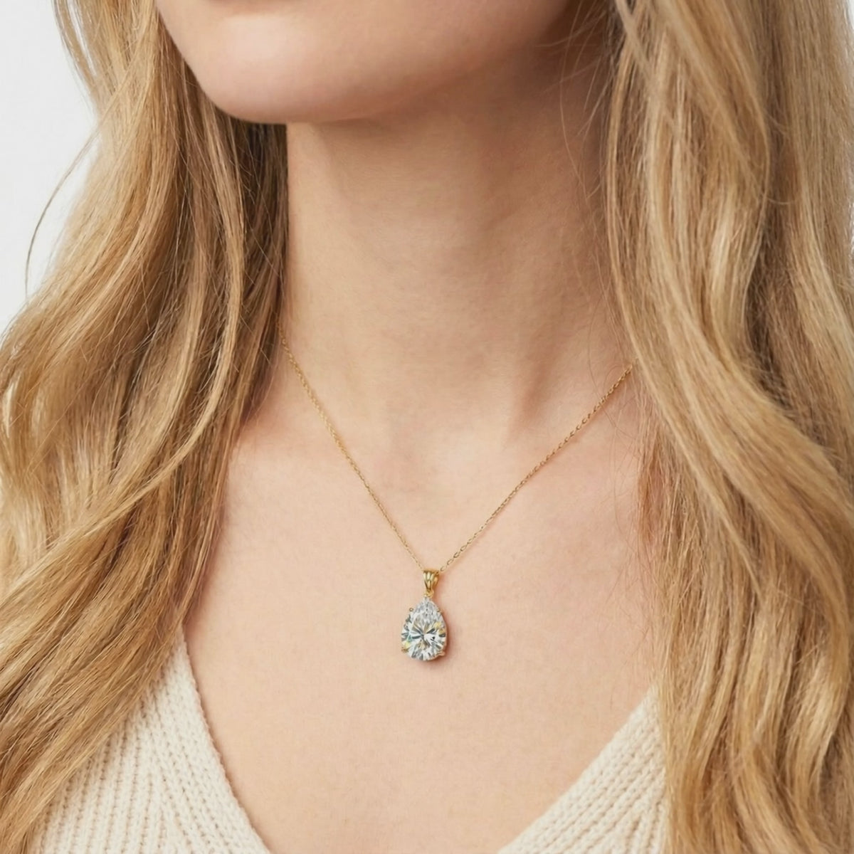 A solid gold necklace with a pear-cut A5 Zirconia pendant.