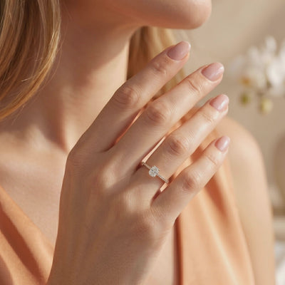 Cushion rectangular solitaire ring with a pavé band worn on a model's ring finger