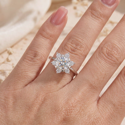 Silver snowflake cluster ring set with round clear gems, shown worn on a hand.