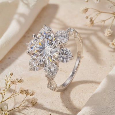 Close-up of the silver Roselita ring standing upright, with a round center stone and floral halo of smaller round stones.