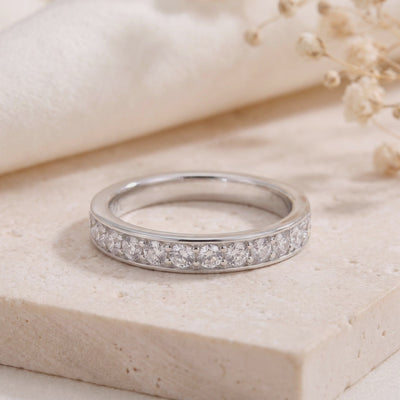 Close-up of the silver eternity ring with channel-set cubic zirconia on a light stone surface.