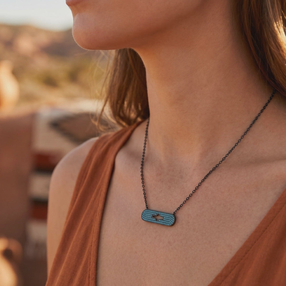 Close-up of a woman wearing the turquoise-studded silver bar necklace with a central star-shaped cutout.