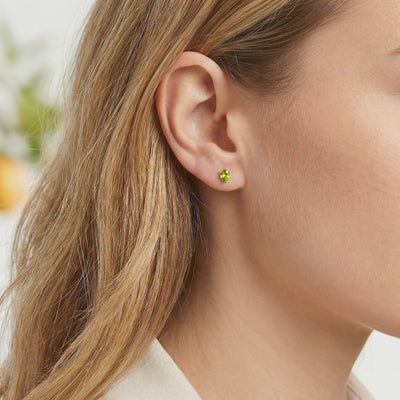 A pair of solid gold earrings with simulated peridot.