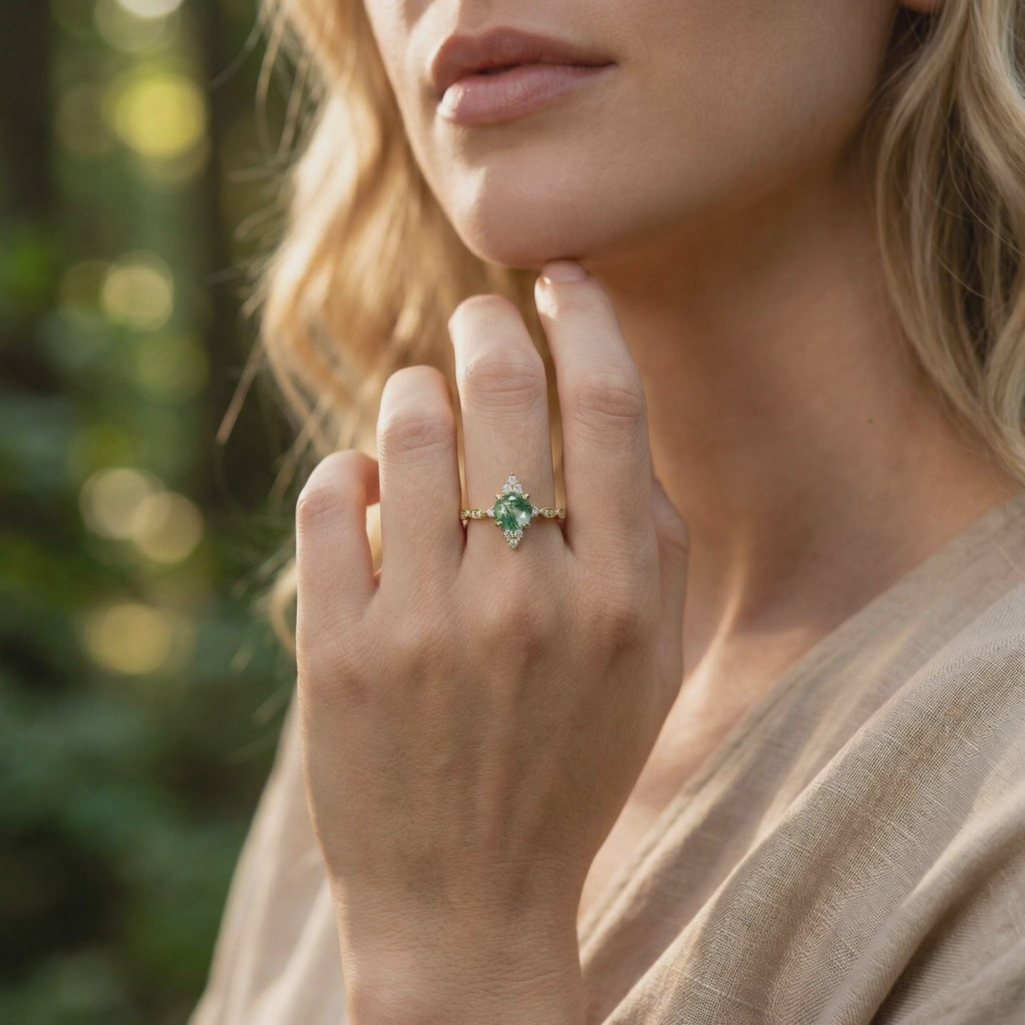 Solid gold ring with a marquise natural moss agate stone in a sunburst setting.