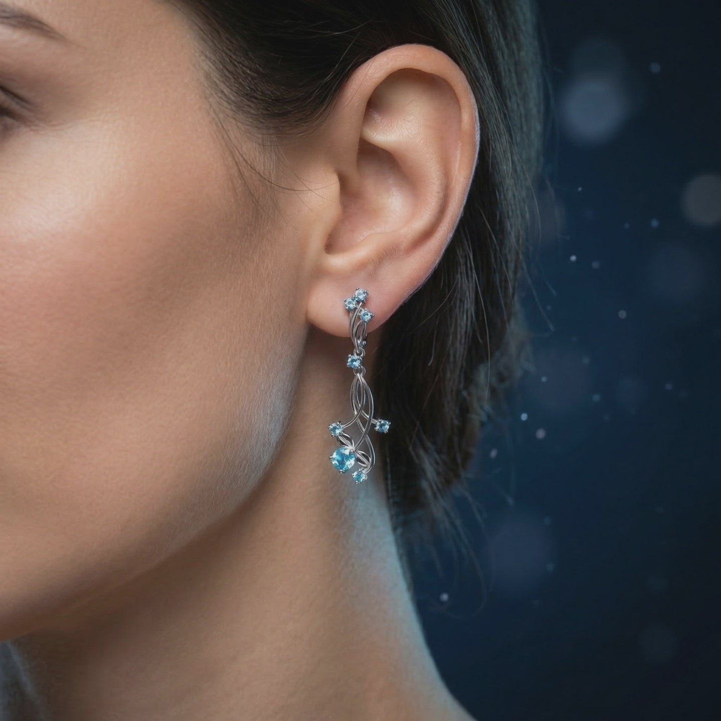 A pair of solid gold earrings with natural blue topaz gemstones.