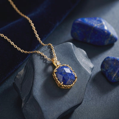 A solid gold necklace with a lapis lazuli pendant.
