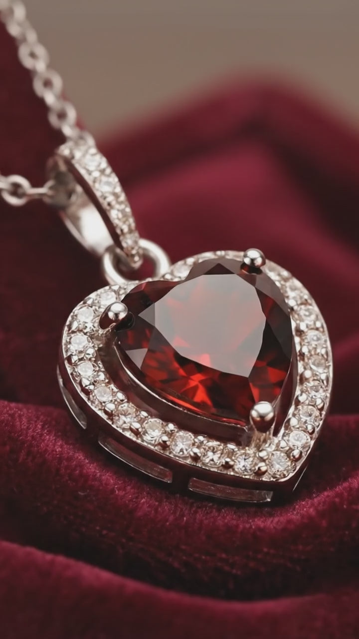 A heart-cut simulated garnet solid gold necklace.