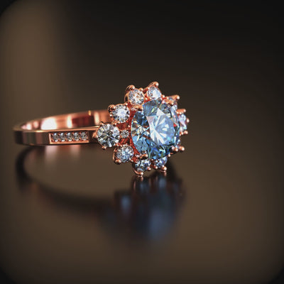 A ring with a blue moissanite center stone and halo in solid gold.