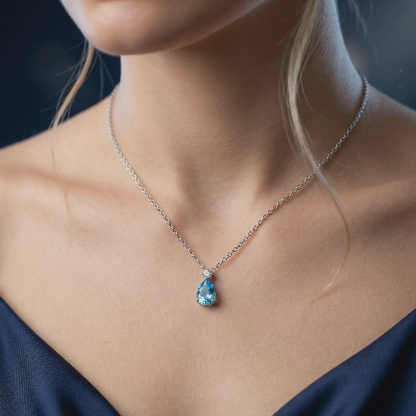 A solid gold necklace with a Swiss Blue topaz gemstone.