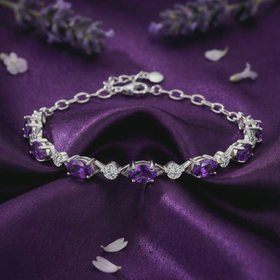 A solid gold station bracelet with natural amethyst and simulated diamond accents.