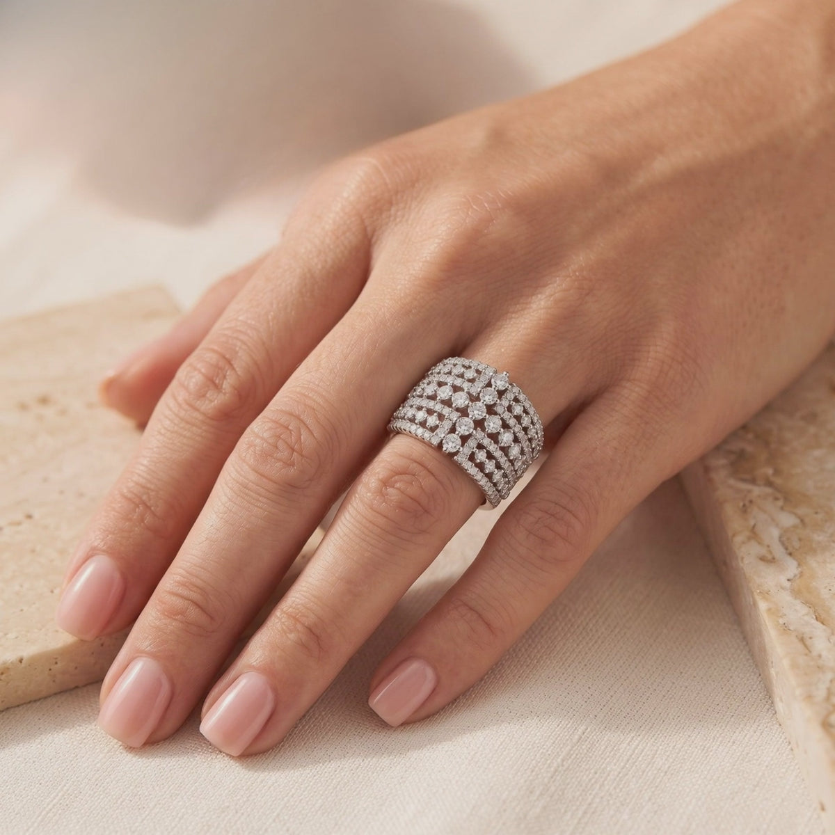 The Eleonora wide silver lattice ring set with clear cubic zirconia stones, shown worn on a hand.