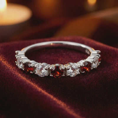A solid gold eternity ring with simulated garnets.