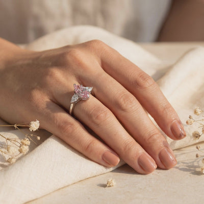 Video preview of a hand wearing a silver ring with a pink marquise stone and pear-cut side stones.