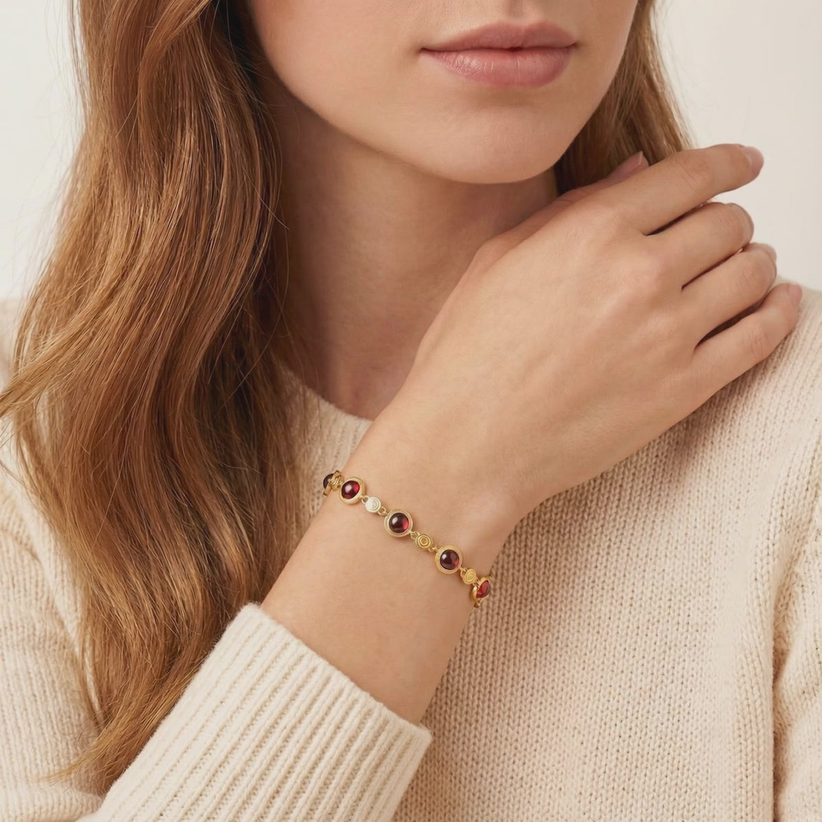 The Calyssa solid gold station bracelet featuring precision-cut simulated garnets.