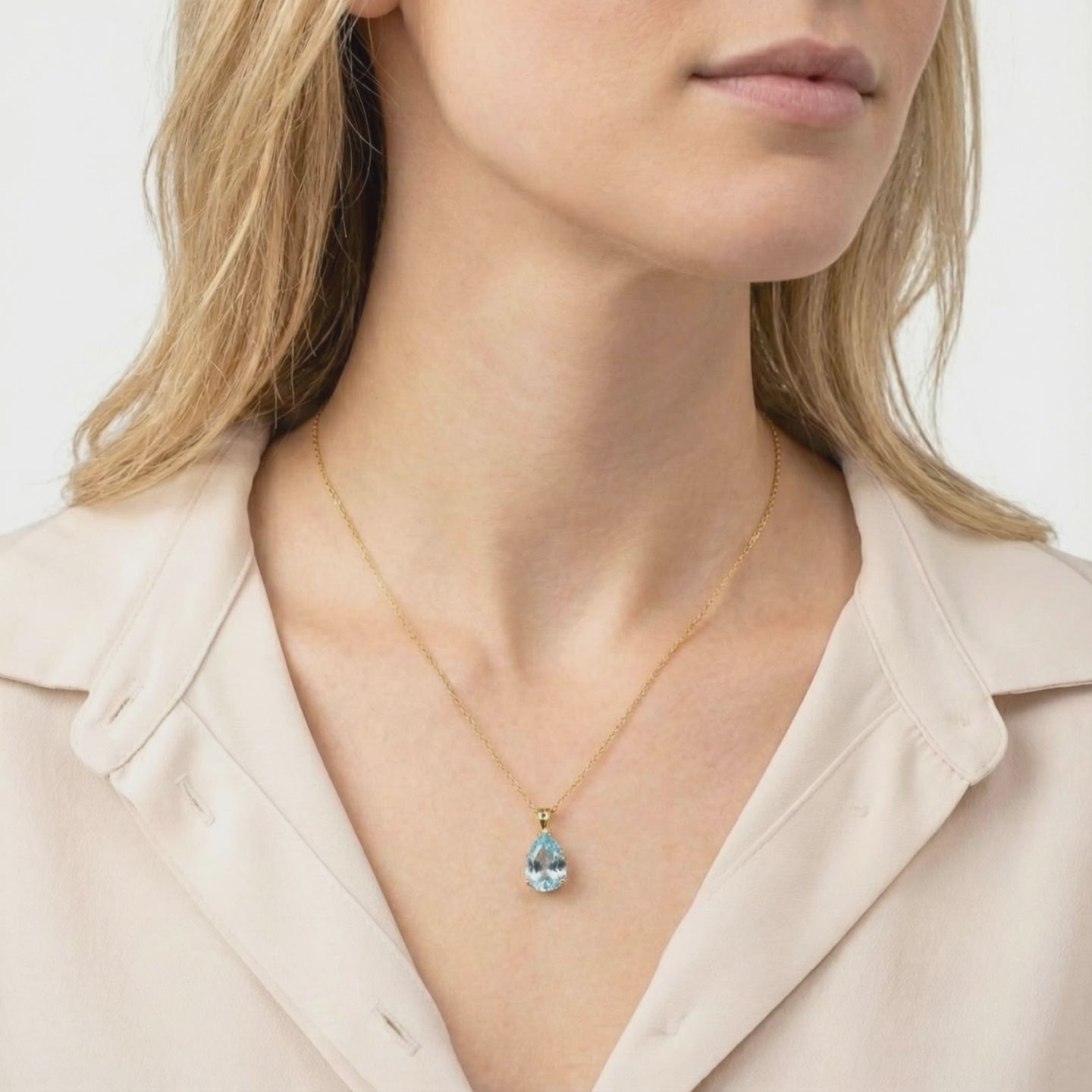 Simulated aquamarine teardrop pendant necklace in solid gold.