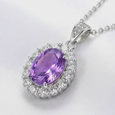 A solid gold necklace with an oval simulated amethyst halo pendant.