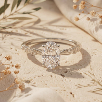 Silver-toned Lysandrielle ring featuring an oval moissanite and twisted pavé band resting on textured stone.
