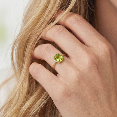 A solid gold ring with a simulated peridot stone.