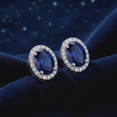 Simulated sapphire halo stud earrings in solid gold.