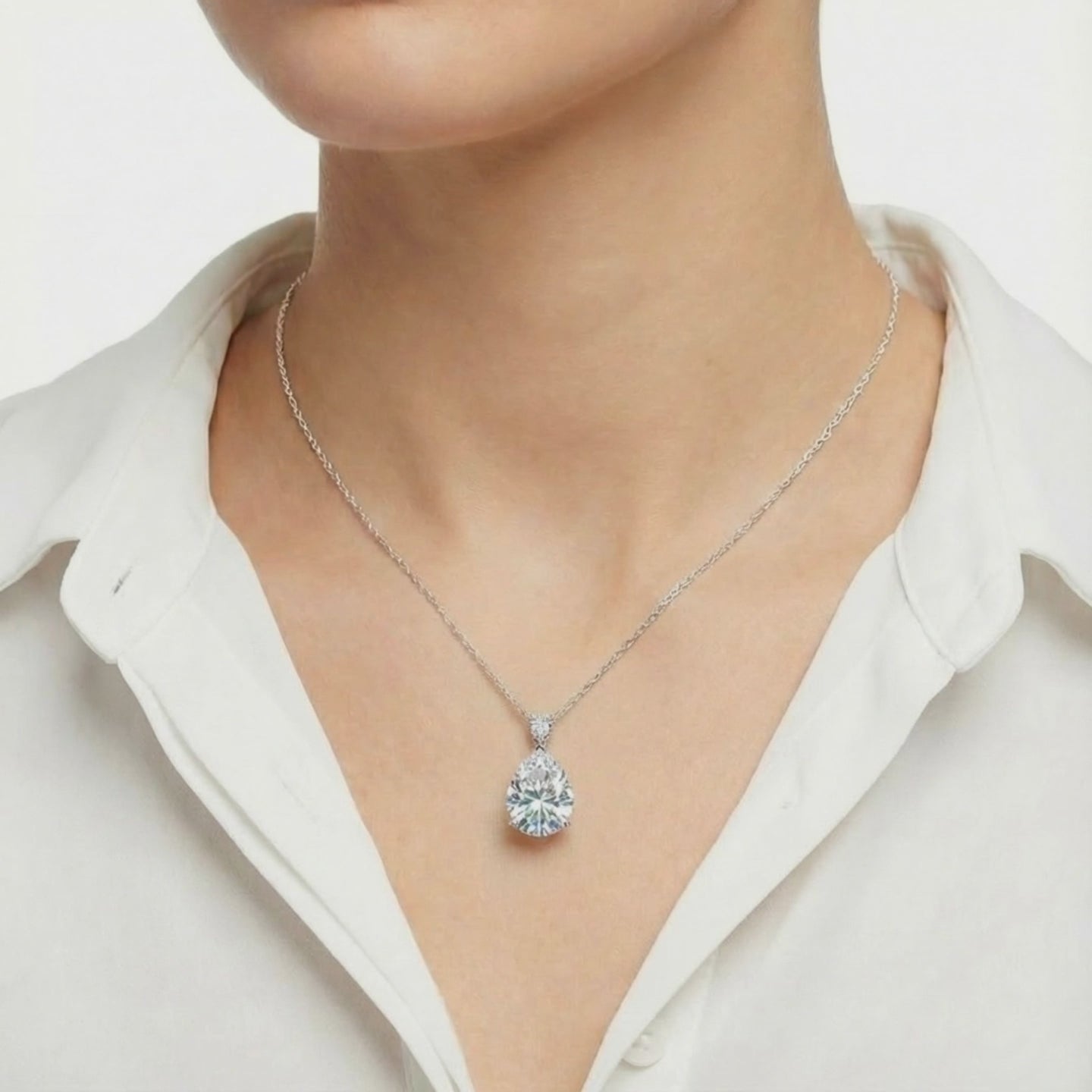 A necklace with a pear-cut moissanite pendant in solid gold.