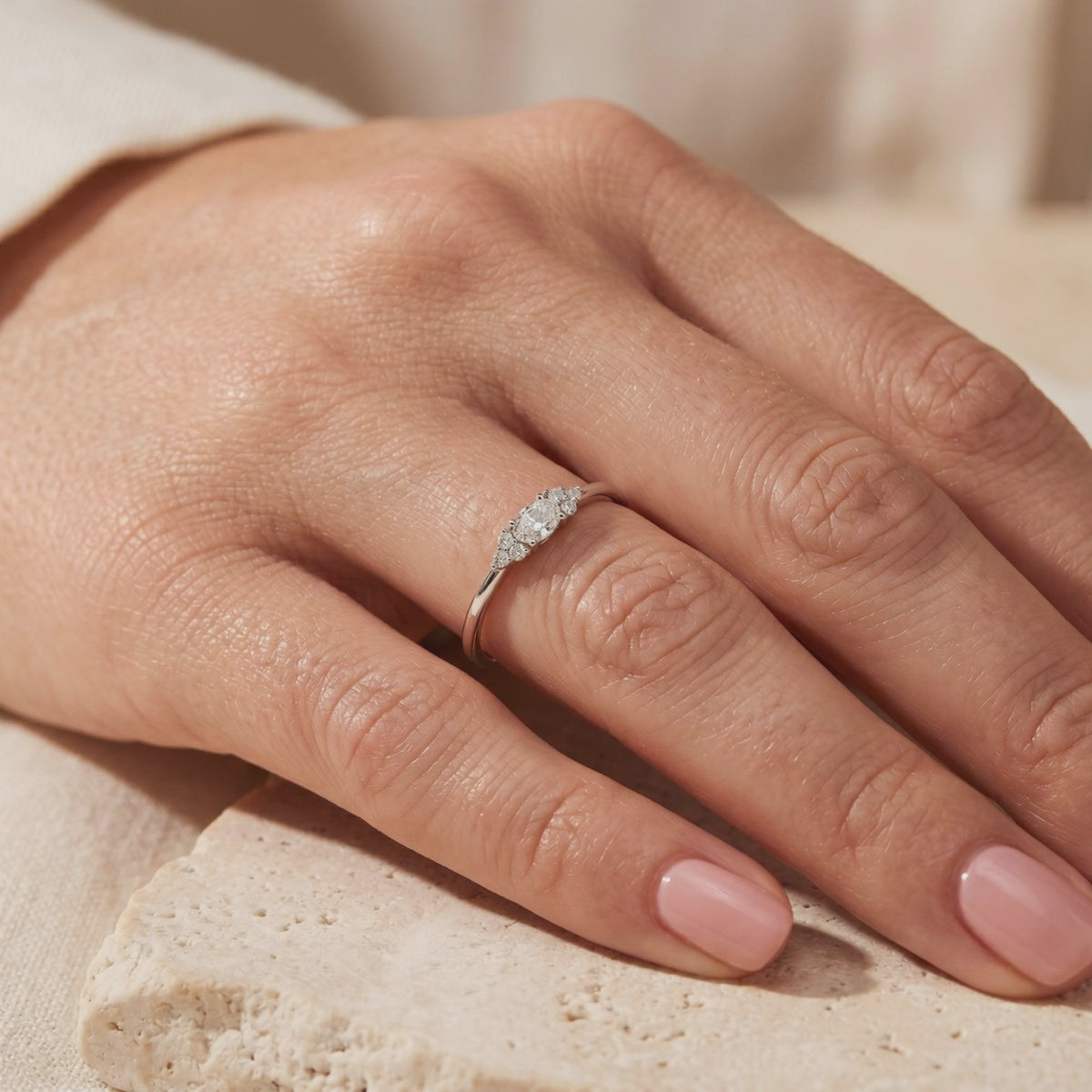 Sterling silver oval moissanite ring with clustered side stones, worn on a hand.