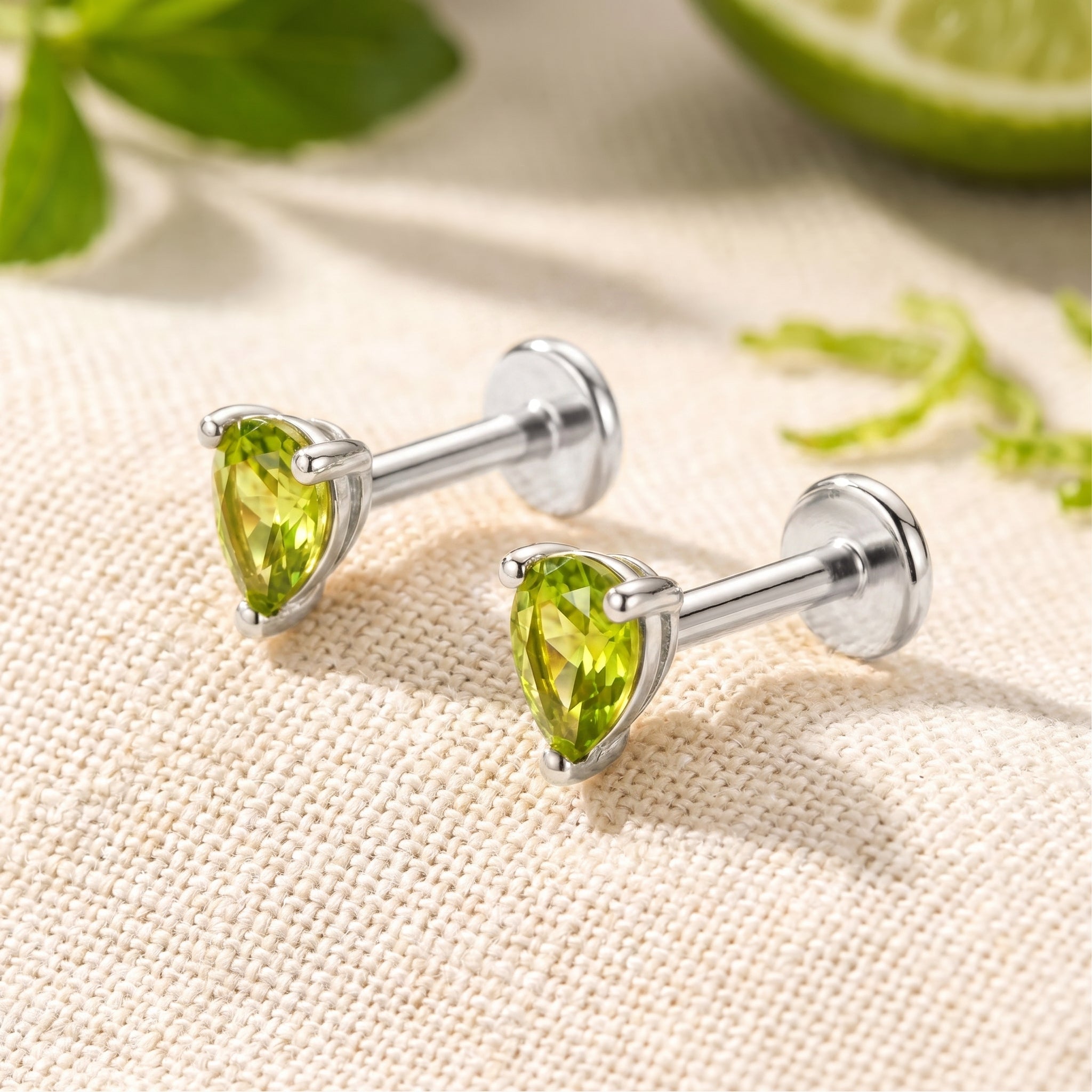 A pair of solid gold earrings with simulated peridot.